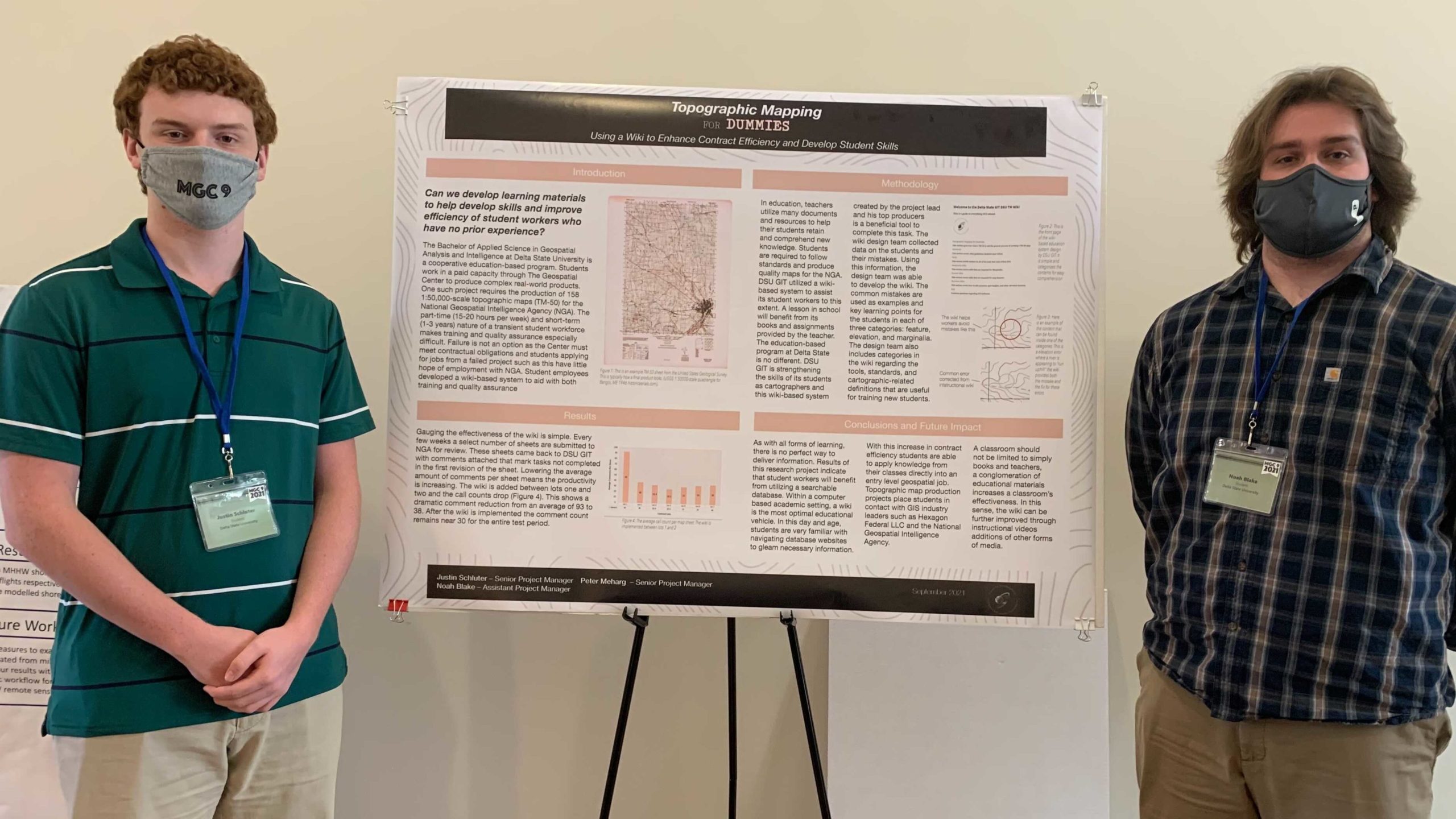 Justin Schluter stands to the left of a poster titled "Topographic Mapping for Dummies Using a Wiki to Enhance Contract Efficiency and Develop Student Skills as Topographic Map Makers". On the right is Noah Blake.